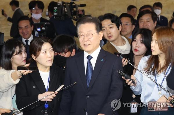 Democratic Party Chairman Lee Jae-myung is surrounded by reporters as he heads to the main hall of the Natio<em></em>nal Assembly building in Seoul on Feb. 27, 2023, ahead of a vote on a motion seeking parliamentary co<em></em>nsent to his arrest over corruption charges. (Yonhap)