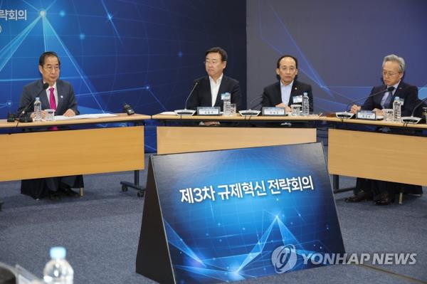 Prime Minister Han Duck-soo (L) presides over a meeting with relevant ministers on regulatory reforms in Seoul on March 2, 2023. (Yonhap)