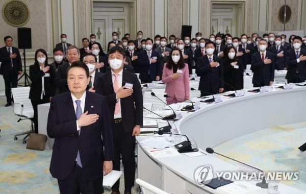 President Yoon Suk Yeol (front) salutes the natio<em></em>nal flag during the unification and interior ministries' joint reports for the year 2023 at Cheong Wa Dae, the former presidential office, in Seoul on Jan. 27, 2023. (Yonhap)