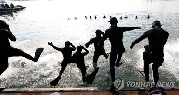 Members of the Navy's Sea Salvage and Rescue Unit jump into waters off a naval port in Jinhae, 410 kilometers south of Seoul, on Jan. 18, 2023, as part of the unit's wintertime drills. (Yonhap)