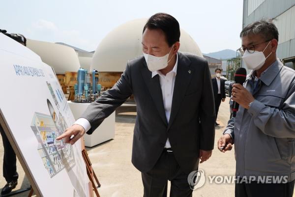 President Yoon Suk Yeol (L) tours a nuclear reactor factory of Doosan Enerbility in Changwon, 301 kilometers southeast of Seoul, in this June 22, 2022, file photo. Yoon pledged to rebuild the nuclear power industry and support its expansion overseas, underscoring his commitment to reversing the nuclear phase-out policy of the previous administration. (Yonhap)