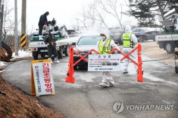 Quarantine officials block a road leading to a pig farm in the county of Yangyang, Gangwon Province, on Feb. 12, 2023, after co<em></em>nfirming an African swine fever case there. (Yonhap)