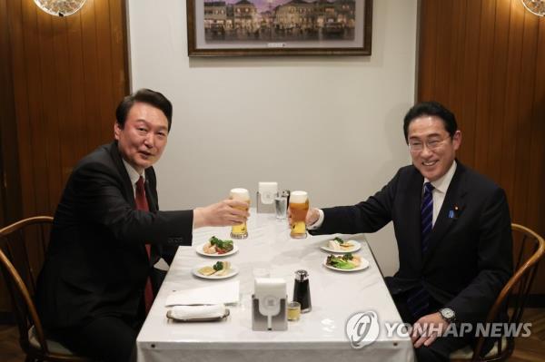 President Yoon Suk Yeol (L) and Japanese Prime Minister Fumio Kishida toast at a restaurant after their summit in Tokyo on March 16, 2023. (Yonhap)