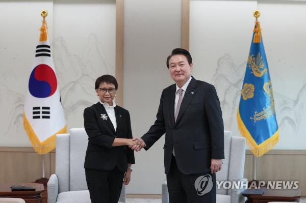 President Yoon Suk Yeol (R) shakes hands with Indo<em></em>nesian Foreign Minister Retno Marsudi during their meeting at the presidential office in Seoul on March 30, 2023, in this photo provided by the presidential office. (PHOTO NOT FOR SALE) (Yonhap)