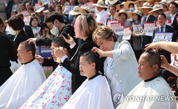 Lawmakers of the main opposition Democratic Party and the heads of a farmers' group stage a head-shavin<em></em>g protest at the Natio<em></em>nal Assembly in western Seoul on April 3, 2023, to oppose President Yoon Suk Yeol's expected veto of a bill requiring government purchase of surplus rice. (Yonhap)