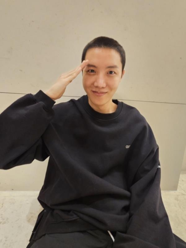 This photo captured from Hybe's Weverse fan community platform shows J-Hope of K-pop boy group BTS giving a salute with a buzz cut. (PHOTO NOT FOR SALE) (Yonhap)
