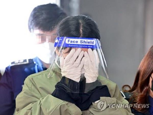 Lee Eun-hae covers her face with both hands while going to attend a court hearing in Incheon, west of Seoul, on April 19, 2022. (Yonhap)