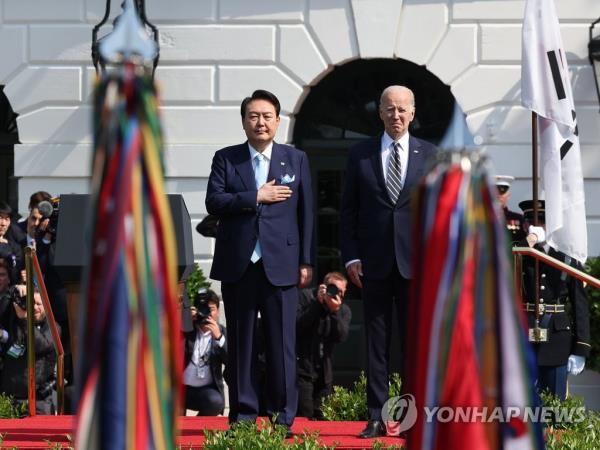 South Korean President Yoon Suk Yeol (L) and U.S. President Joe Biden attend an official welcoming event ahead of their summit at the White House in Washington, D.C., on April 26, 2023. (Yonhap)