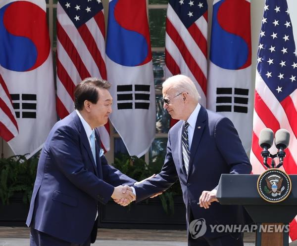 South Korean President Yoon Suk Yeol (L) shakes hands with U.S. President Joe Biden during a joint news co<em></em>nference after their summit at the White House in Washington, D.C., on April 26, 2023. (Yonhap)