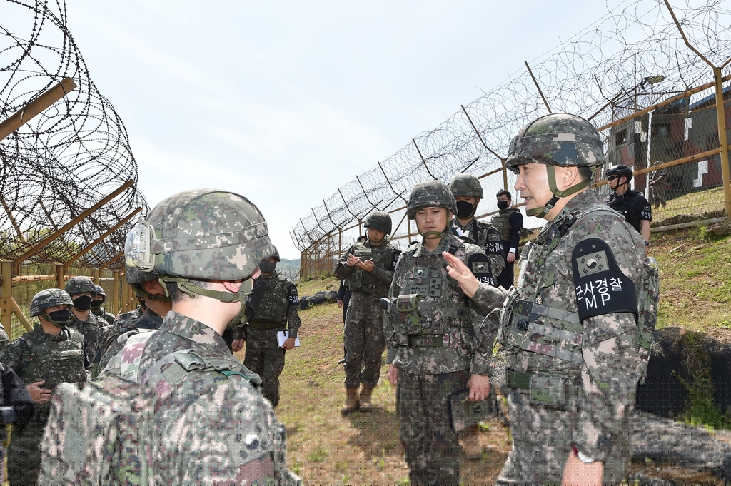 Joint Chiefs of Staff (JCS) Chairman Gen. Kim Seung-kyum (R) speaks to 25th Infantry Division troops statio<em></em>ned at a guard post inside the Demilitarized Zone on the western fro<em></em>ntline on May 3, 2023, in this photo provided by the JCS. (PHOTO NOT FOR SALE) (Yonhap)