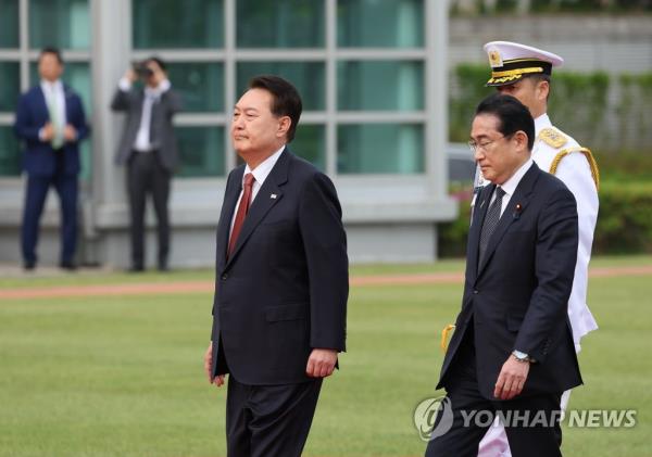 President Yoon Suk Yeol (L) and Japanese Prime Minister Fumio Kishida (R) inspect an ho<em></em>nor guard during an official arrival ceremony for the Japanese leader at the presidential office in Seoul on May 7, 2023. (Yonhap)