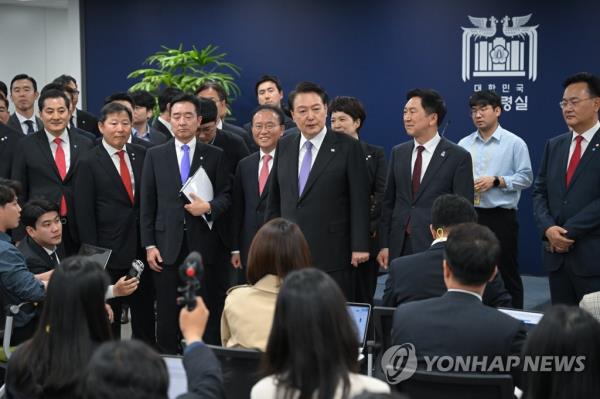 President Yoon Suk Yeol (5th from L) speaks to reporters during a visit to the press room of the presidential office in Seoul on May 10, 2023, in this photo provided by his office. (PHOTO NOT FOR SALE) (Yonhap)