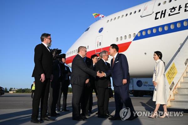 South Korean President Yoon Suk Yeol (2nd from R), alo<em></em>ngside his wife Kim Keon Hee (far R), is welcomed after arriving at Vilnius Internatio<em></em>nal Airport in the Lithuanian capital on July 10, 2023, to attend a North Atlantic Treaty Organization (NATO) summit. (Pool photo) (Yonhap)