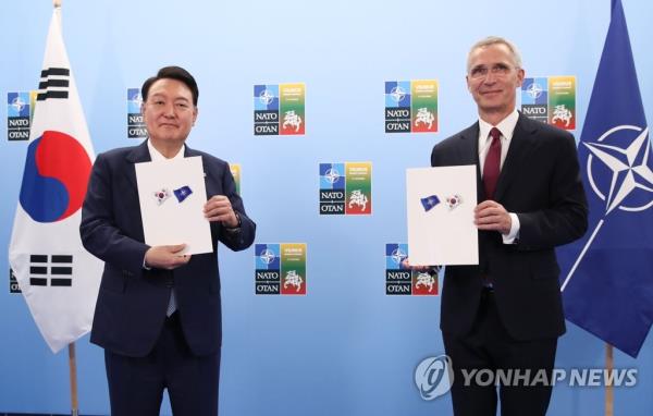 South Korean President Yoon Suk Yeol (L) and North Atlantic Treaty Organization (NATO) Secretary-General Jens Stoltenberg pose for a photo after signing the Individually Tailored Partnership Program during their meeting at the venue of a NATO summit in Vilnius, Lithuania, on July 11, 2023. (Yonhap)