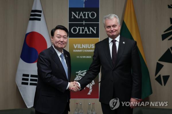 South Korean President Yoon Suk Yeol (L) shakes hands with Lithuanian President Gitanas Nauseda during their talks in Vilnius, Lithuania, on July 12, 2023, on the sidelines of a summit of the North Atlantic Treaty Organization. (Pool photo) (Yonhap)