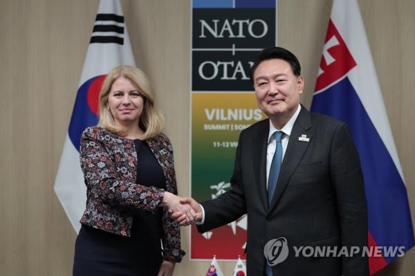 South Korean President Yoon Suk Yeol (R) shakes hands with Slovak President Zuzana Caputova during their talks in Vilnius, Lithuania, on July 12, 2023, on the sidelines of a summit of the North Atlantic Treaty Organization. (Pool photo) (Yonhap)
