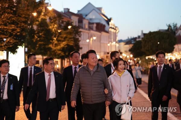South Korean President Yoon Suk Yeol (C) and his wife, Kim Keon Hee (2nd from R), take a stroll in the Old Town of Vilnius, one of the best preserved in Northern Europe, which was inscribed o<em></em>nto the World Heritage List in 1994, in the Lithuanian capital on July 10, 2023. Yoon arrived in the European country to attend a summit of the North Atlantic Treaty Organization. (Pool photo) (Yonhap)