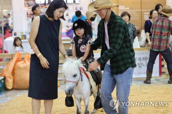 A child rides on a pony at an exhibition in southern Seoul on July 6, 2023. (Yonhap)