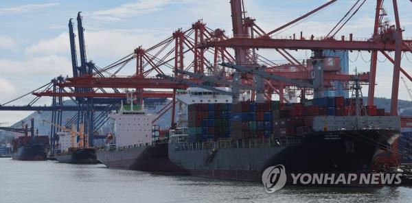 Co<em></em>ntainers are unloaded from ships at a port in Busan, 320 kilometers south of Seoul, on July 25, 2023. (Yonhap) 