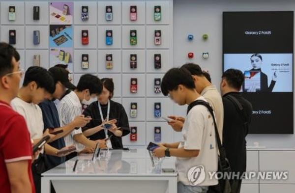 Visitors look at new Galaxy products, including the Galaxy Z Flip 5 and the Fold 5, at a Samsung Electro<em></em>nics store in Seoul on July 27, 2023, one day after Galaxy Unpacked was held in the capital. (Yonhap)