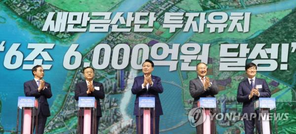 In this photo taken Aug. 2, 2023, (from left) First Land and Transport Minister Kim Oh-jin, LS Corp. CEO Myung Roe-hyun, President Yoon Suk Yeol, LS Group Chairman Koo Ja-eun and L&F Director Huh Je-hong clap their hands during a signing ceremony for LS Group's project to build a plant for precursors, held at the Gunsan Saemangeum Co<em></em>nvention Center in Gunsan, 178 kilometers southwest of Seoul, in this photo provided by the presidential office. (PHOTO NOT FOR SALE) (Yonhap)