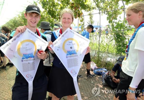 Attendees of the 25th World Scout Jamboree hold up traditio<em></em>nal Korean kites they made at a campsite in the Saemangeum reclamation area in Buan, North Jeolla Province, on South Korea's west coast on Aug. 4, 2023. (Yonhap)