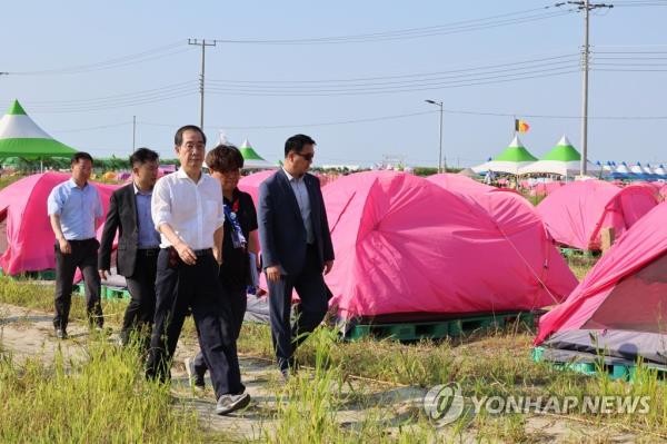 South Korean Prime Minister Han Duck-soo (front) visits a campsite at the 25th World Scout Jamboree in the Saemangeum reclamation area in Buan, North Jeolla Province, on South Korea's west coast, on Aug. 4, 2023. (Yonhap)