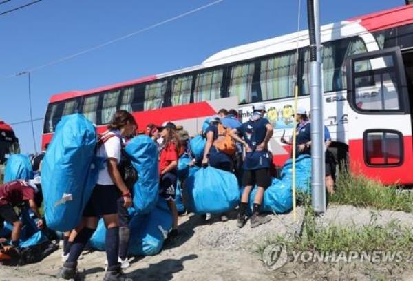 Young Scouts prepare to board a bus to leave Saemangeum, the venue of the 25th World Scout Jamboree, on Aug. 8, 2023, for new accommodations in other parts of South Korea. (Yonhap)