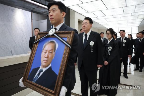 President Yoon Suk Yeol (2nd from L) and first lady Kim Keon Hee (3rd from L) walk behind a portrait of Yoon's late father, Yoon Ki-jung, during his funeral at Severance Hospital in Seoul on Aug. 17, 2023, in this photo provided by the presidential office. (PHOTO NOT FOR SALE) (Yonhap)