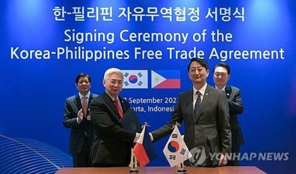 South Korean Trade Minister Ahn Duk-geun (R, front) and his Philippine counterpart, Alfredo Espinosa Pascual (L, front), shake hands after signing the South Korea-Philippines Free Trade Agreement in Jakarta on Sept. 7, 2023, with South Korean President Yoon Suk Yeol (R, back) and Philippine President Ferdinand Marcos Jr. in attendance. (Yonhap)