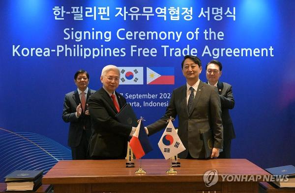 South Korean Trade Minister Ahn Duk-geun (2nd from R) and his Philippine counterpart, Alfredo Espinosa Pascual (2nd from L), shake hands after signing the South Korea-Philippines free trade agreement at a hotel in Jakarta on Sept. 7, 2023, with South Korean President Yoon Suk Yeol (R) and Philippine President Ferdinand Marcos Jr. in attendance. (Yonhap)
