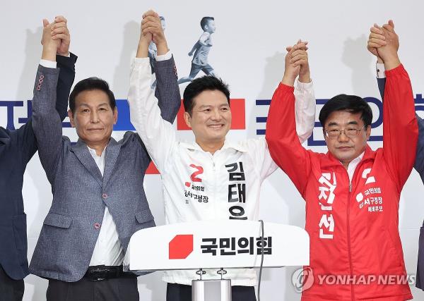 Former Gangseo Ward office chief Kim Tae-woo holds hands with members of the People Power Party after the election results at the Natio<em></em>nal Assembly in Seoul on Sept. 17, 2023. (Pool photo) (Yonhap)