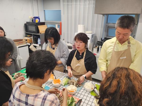 Participants in the cooking program designed for single-person households in Jung-gu district, central Seoul, listen to instructions by the chef on how to prepare vegetables on Sept. 26, 2023. (Yonhap)