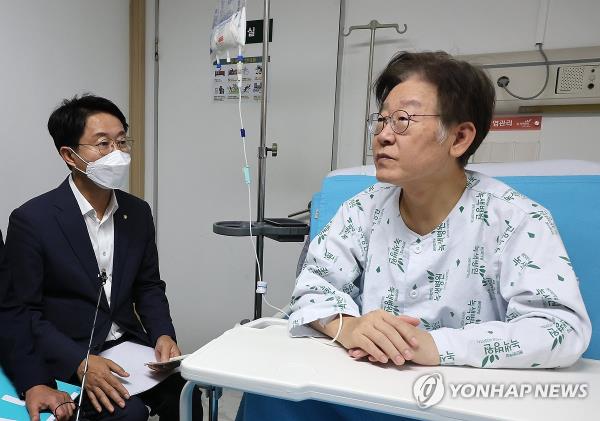 Lee Jae-myung, chair of the Democratic Party, is briefed by a party official on Sept. 28, 2023, at a hospital in Seoul wher<em></em>e he is under treatment following a 24-day hunger strike. (Yonhap)