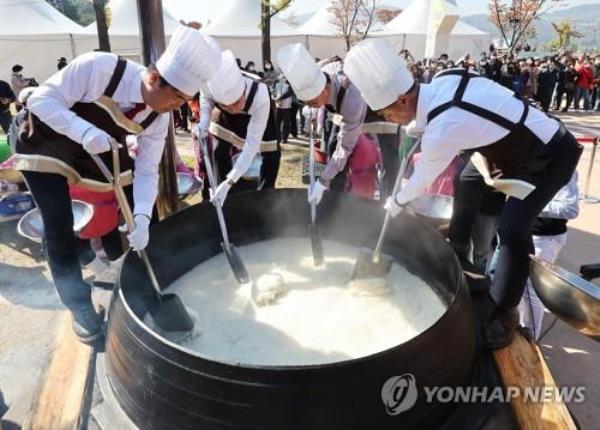 People shovel steamed rice for 2,000 servings from a large iron pot during the Icheon Rice Cultural Festival held in the city of Icheon, south of Seoul, on Oct. 20, 2022. (Yonhap) 