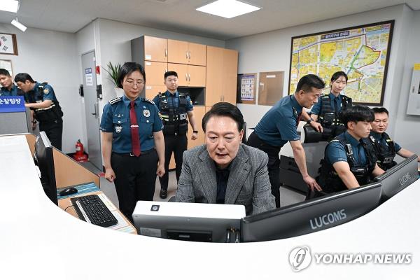 This photo provided by the presidential office on Sept. 30, 2023, shows President Yoon Suk Yeol (C) visiting the Jungbu Police Station in central Seoul to encourage police perso<em></em>nnel on duty during the Chuseok holiday. (PHOTO NOT FOR SALE) (Yonhap)