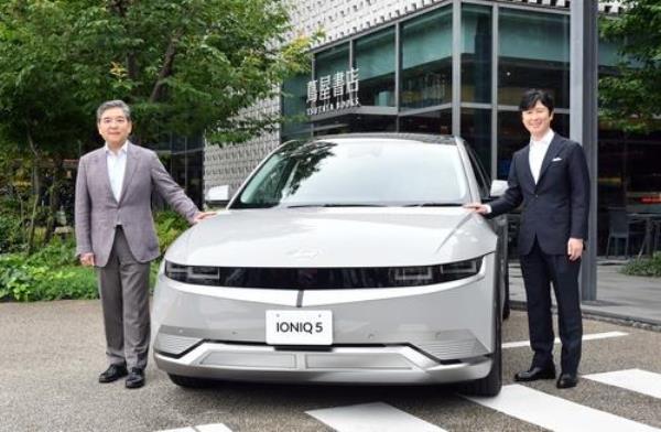 Hyundai Motor President and CEO Chang Jae-hoon (L) and CCC President and Chief Operating Officer Yasunori Takahashi pose for a photo with the carmaker's all-electric Io<em></em>niq 5 model outside the large Daikanyama T-Site Tsutaya bookstore in Tokyo on June 22, 2023, in this file photo provided by the South Korean company. (PHOTO NOT FOR SALE) (Yonhap)