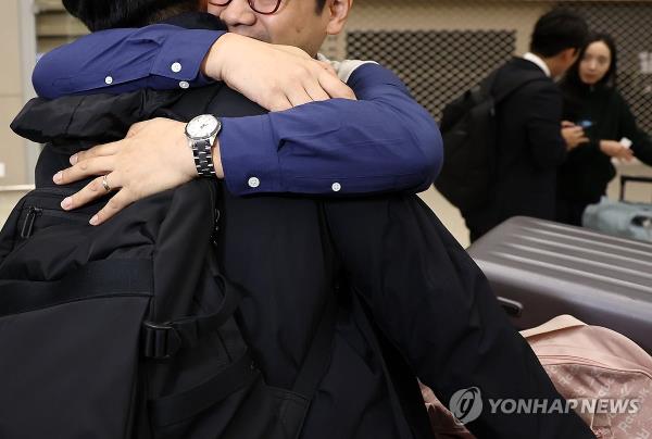 A man embraces another at Incheon Internatio<em></em>nal Airport, west of Seoul, on Oct. 11, 2023, after safely arriving home from Israel in the wake of the Hamas attack. (Yonhap) 