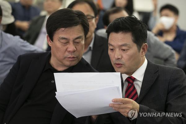 Kim Tae-woo (R), the candidate of the ruling People Power Party in the by-election for the new chief of Seoul's Gangseo Ward, speaks to a party official as he waits for the results at his campaign office on Oct. 11, 2023. (Pool photo) (Yonhap)