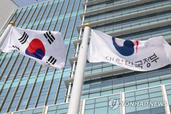 The Taegeukgi (L), South Korea's natio<em></em>nal flag, and a flag of the government flutter in the wind in this undated photo. (Yonhap)