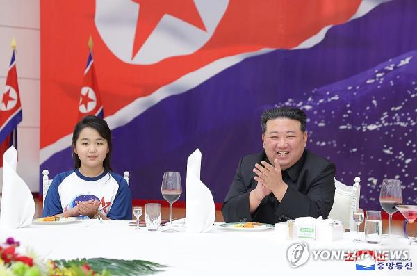 This photo, carried by North Korea's official Korean Central News Agency on Nov. 24, 2023, shows the North's leader Kim Jong-un (R) and his daughter, believed to be named Ju-ae, attending a banquet the previous day to celebrate the country's successful launch of a military spy satellite. (For Use o<em></em>nly in the Republic of Korea. No Redistribution) (Yonhap)