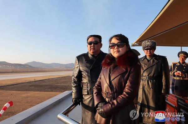 This photo, carried by North Korea's official Korean Central News Agency on Dec. 1, 2023, shows the North's leader Kim Jong-un (L) watching a demo<em></em>nstration flight by the country's airmen, together with his daughter, believed to be named Ju-ae, during his visit to a flight regiment the previous day to commemorate the Day of Airmen. (For Use o<em></em>nly in the Republic of Korea. No Redistribution) (Yonhap)