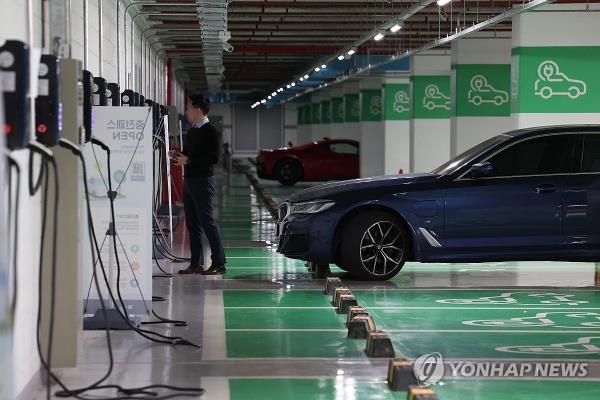 A man charges his electric vehicle at a charging station in Seoul on Oct. 29, 2023. (Yonhap)